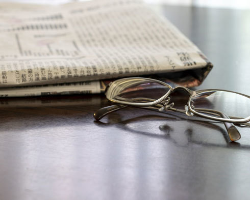 テーブルの上の新聞と眼鏡